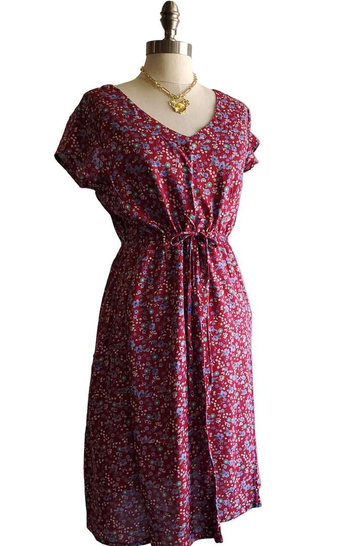 Red floral dress on a mannequin against a plain background